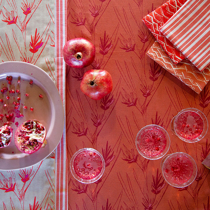 Gin, prosecco and pomegranate cocktail with terracotta and geranium tea towels, napkins and tablecloths ships from Canada worldwide