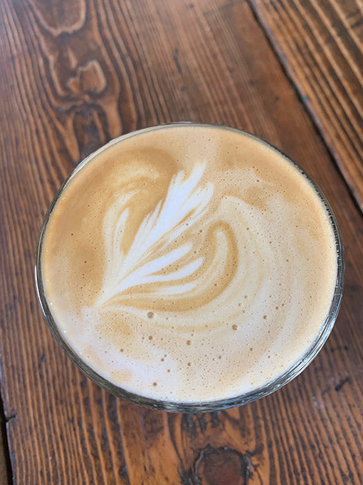 Cappuccino with latte art on a wooden surface