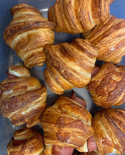 Croissants with visible layers on a metal surface